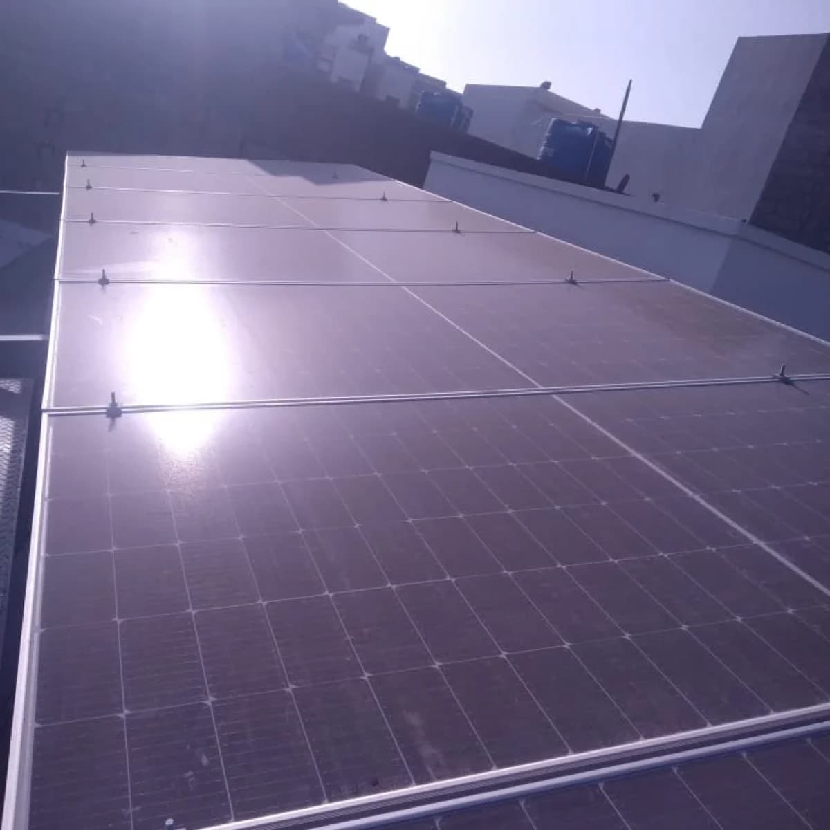 Sunlit solar panel array on a Karachi rooftop